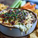 Creamy Smoked Gouda & Onion Dip in a baking dish, paired with crunchy tortilla chips ready for scooping at a party.