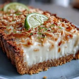 Zesty lime filling meets tropical coconut in a crisp graham cracker crust, perfect for a refreshing summer dessert.