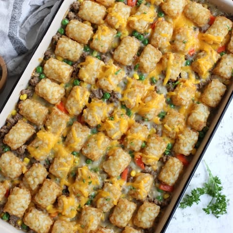 Steaming Tater Tot Casserole fresh from the oven, served in a rustic dish for a perfect family weeknight dinner.