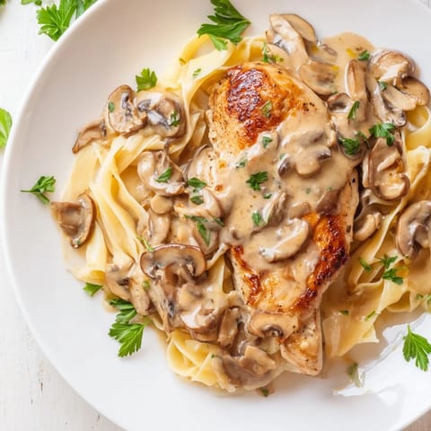 Creamy Chicken Marsala features tender chicken in a rich wine sauce, garnished with fresh parsley and optional Parmesan cheese.  
