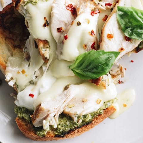 Crisp sourdough toast is layered with pesto and tender chicken, topped with creamy burrata for an appetizer.  