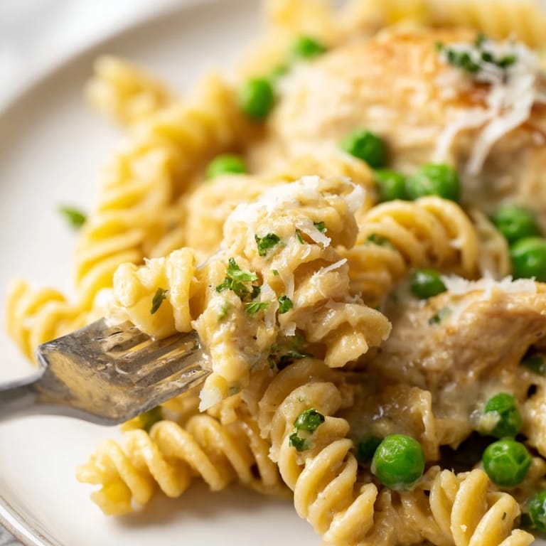 Savory Garlic Butter Chicken & Pea Pasta served warm in a skillet, featuring tender pasta twists and bright green peas for a comforting family meal.