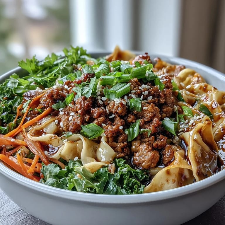 A close-up shows glossy noodles coated in rich sauce with savory pork in Potsticker Noodle Bowls for an easy weeknight meal.